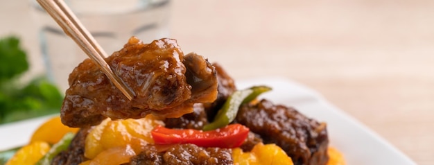 Costillas de cerdo fritas en salsa agridulce con pimienta picada y piña