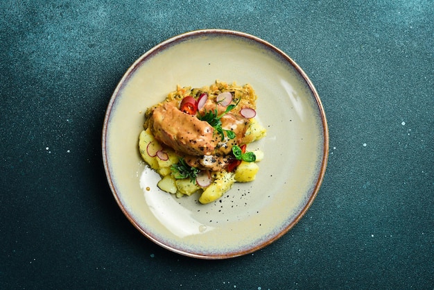 Costillas de cerdo guisadas en salsa de crema con patatas hervidas en un plato Restaurante que sirve de cerca sobre un fondo de piedra oscura