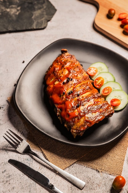 Costillas de cerdo a la parrilla BBQ en plato negro Vista superiorDía mundial de la comida