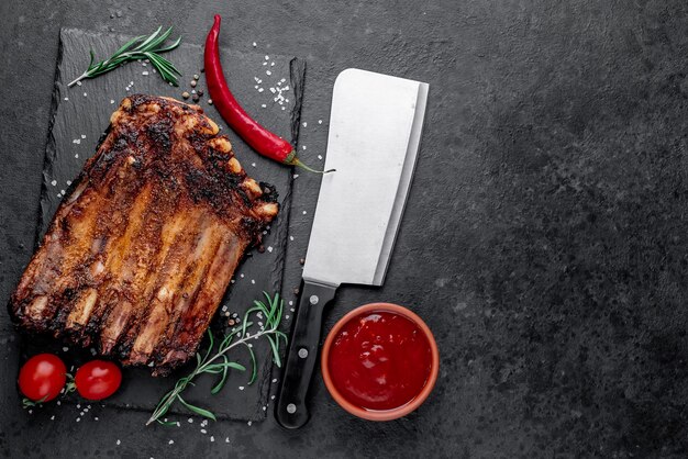 Costillas de cerdo a la parrilla sobre fondo de piedra con espacio para copiar el texto