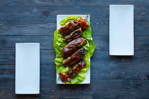 Costillas de cerdo a la parrilla con verduras sobre un fondo de madera