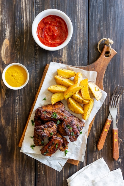 Costillas de cerdo con patatas en una mesa de madera. Parilla. Parrilla. Cocina americana. Receta.