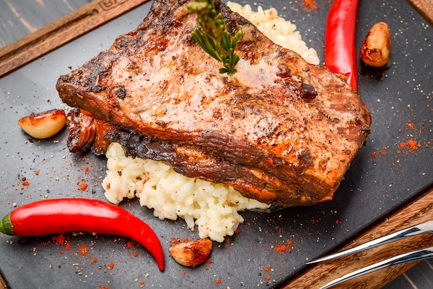 Costillas de cerdo a la plancha con arroz en mesa de madera