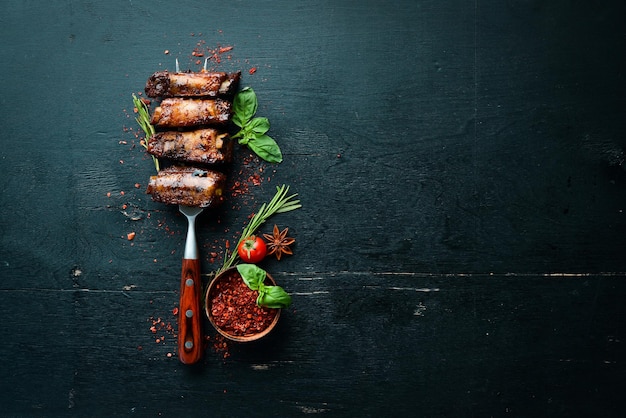 Costillas de cerdo en el tenedor Sobre un fondo de madera Vista superior Espacio libre para el texto