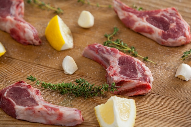 Costillas chuletas, limón y ajo sobre tabla de madera