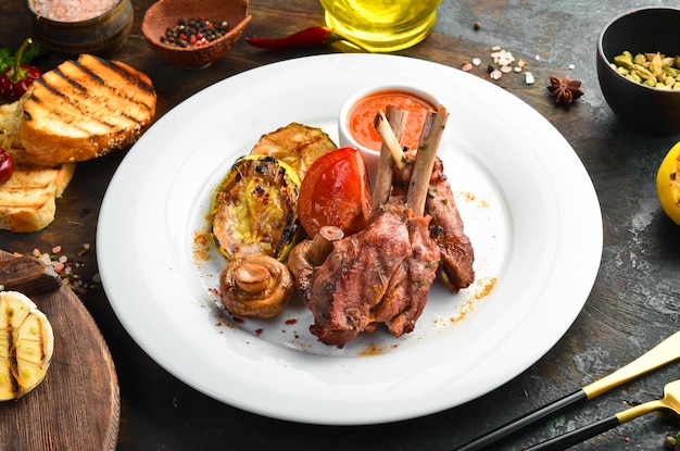 Costillas de cordero al horno con verduras en un plato. Vista superior.