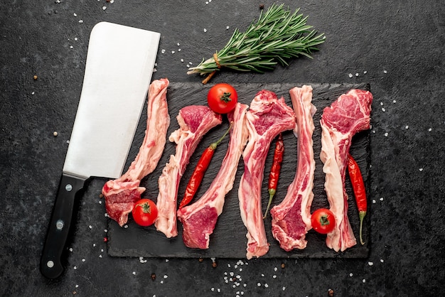 Costillas de cordero crudo con especias sobre un fondo de piedra