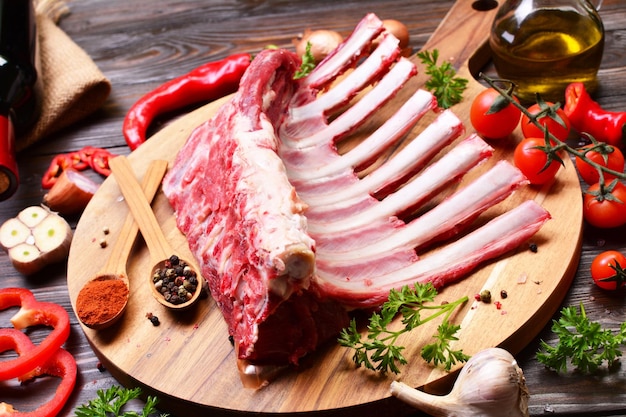 Costillas de cordero con especias y verduras sobre fondo de madera