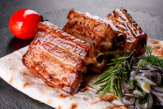 Costillas fritas con romero, cebolla, salsa. Mesa oscura