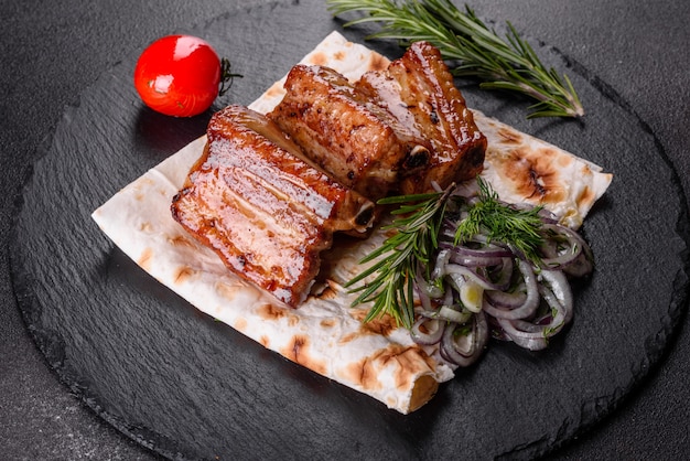 Costillas fritas con romero, cebolla, salsa. Mesa oscura