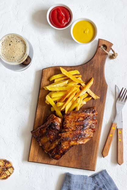 Costillas a la parrilla con papas fritas. Cocina americana. Parrilla. Barbacoa.