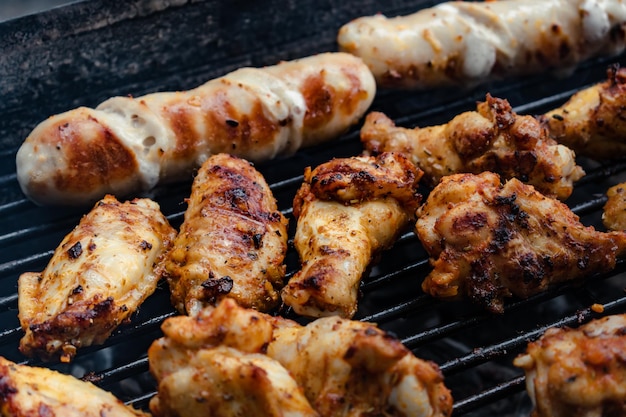 Costillas de pollo de carne marinada y salchichas puestas a la barbacoa