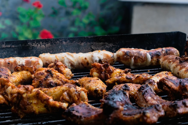 Costillas de pollo de carne marinada y salchichas puestas a la barbacoa