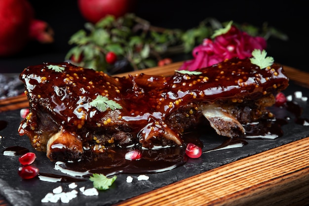 Costillas con salsa, sobre tabla de madera