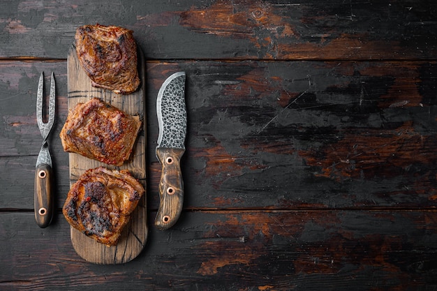 Costillas de ternera estofadas caseras, sobre fondo de mesa de madera oscura antigua, vista superior plana, con espacio para copiar texto