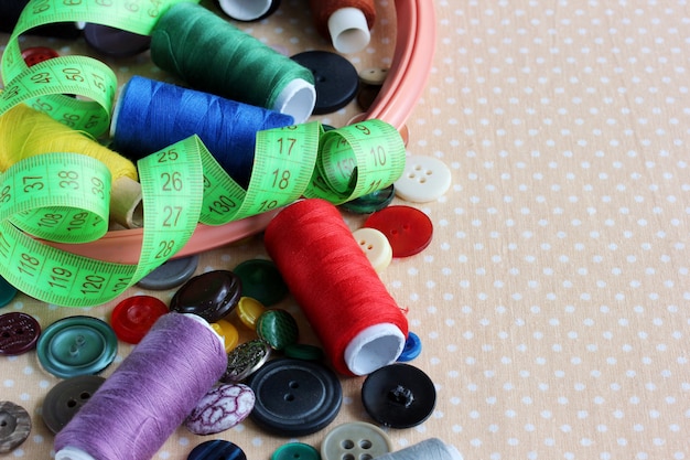 Costura y costura: diferentes botones, hilos de colores, aros y cinta para medir la mesa.