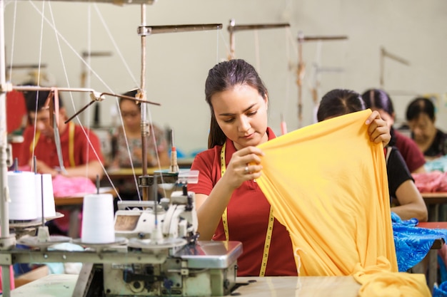 Costurera en fábrica textil cosiendo con costura industrial