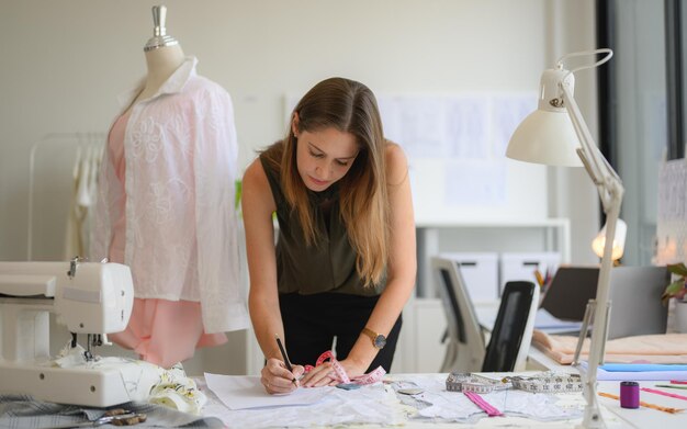 Foto una costurera feliz trabajando en un taller.