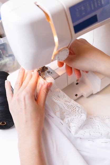 Costurera garabatea tela en máquina de coser