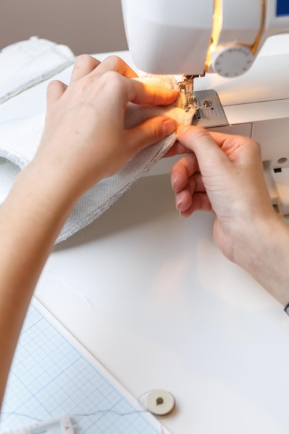 Costurera hace puntadas en tela en máquina de coser