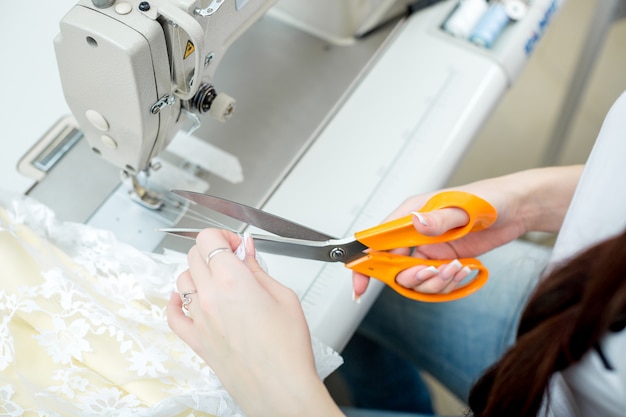 Costurera de niña cose en la máquina de coser