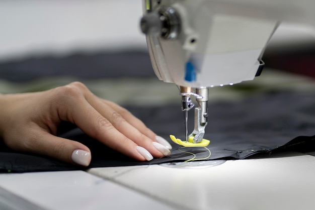 Foto costurera trabajó en la fábrica usando una máquina de coser de primer plano