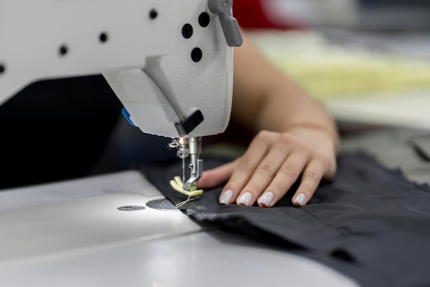 Foto costurera trabajó en la fábrica usando una máquina de coser de primer plano