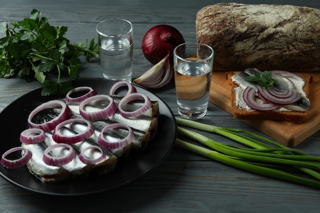 Cotas de vodka e petiscos saborosos na mesa de madeira