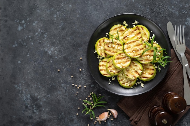 Courgette de abobrinha grelhada com alho e alecrim na vista superior do prato