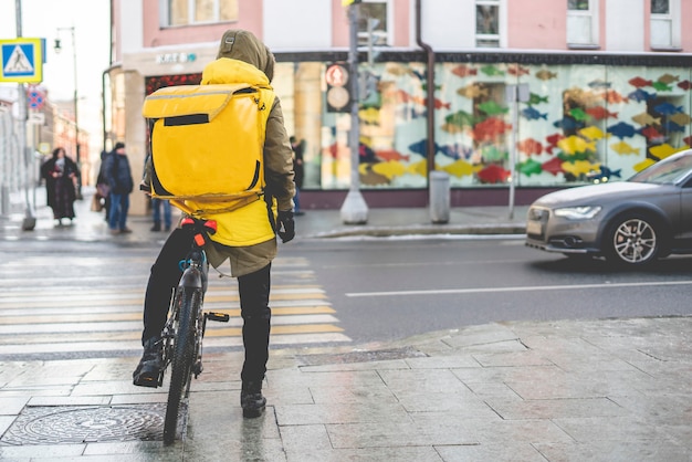 Courier em bicicleta entrega comida saborosa nas ruas da cidade b