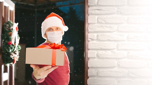 Courier entrega un regalo en Nochebuena con una máscara del coronavirus