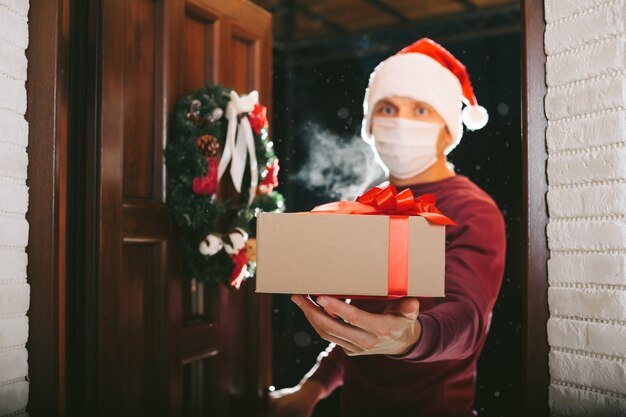 Courier entrega un regalo en Nochebuena con una máscara del coronavirus