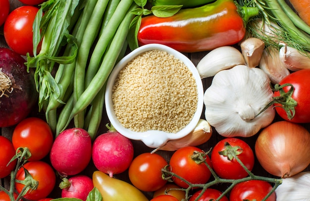 CousCous en un tazón y vista superior de verduras frescas