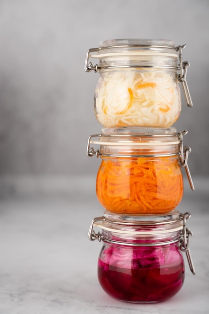 Couve fermentada caseira de aldeia repolho vermelho e cenoura coreana em frascos de vidro fundo cinzento