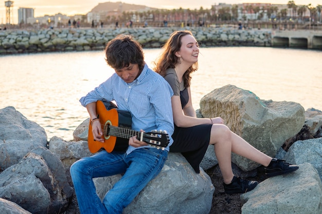 Coverband paar Musiker spielen Akustikgitarre und singen in Strandnähe. Meer im Hintergrund