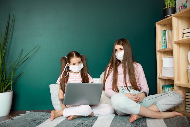 Covid-19 Coronavirus y Aprendiendo del concepto de hogar. estudio de chicas con aprendizaje en línea con laptop