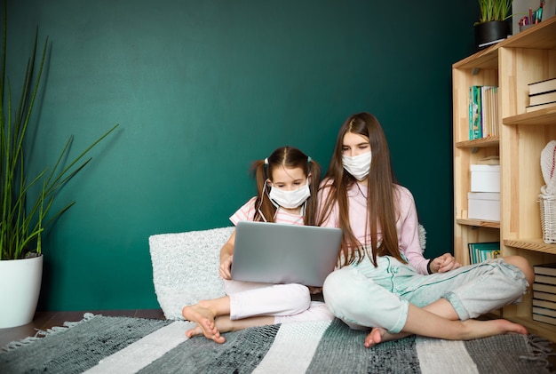 Covid-19 Coronavirus y Aprendiendo del concepto de hogar. estudio de chicas con aprendizaje en línea con laptop