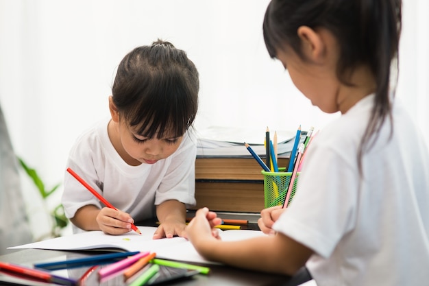 Covid-19 Coronavirus e Aprendendo em casa, conceito de criança da escola em casa. As crianças pequenas estudam a aprendizagem online em casa com um laptop.