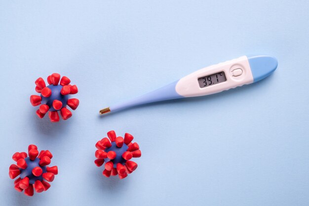 COVID-19, Coronavirus-Konzept. Elektronisches Thermometer und Modelle des Covid-19-Virus