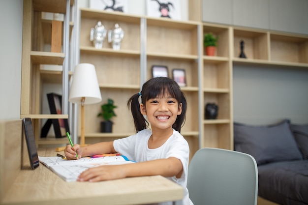 Covid-19 Coronavirus y Learning from home, concepto de niño de escuela en casa. Los niños pequeños estudian el aprendizaje en línea desde casa con una computadora portátil.