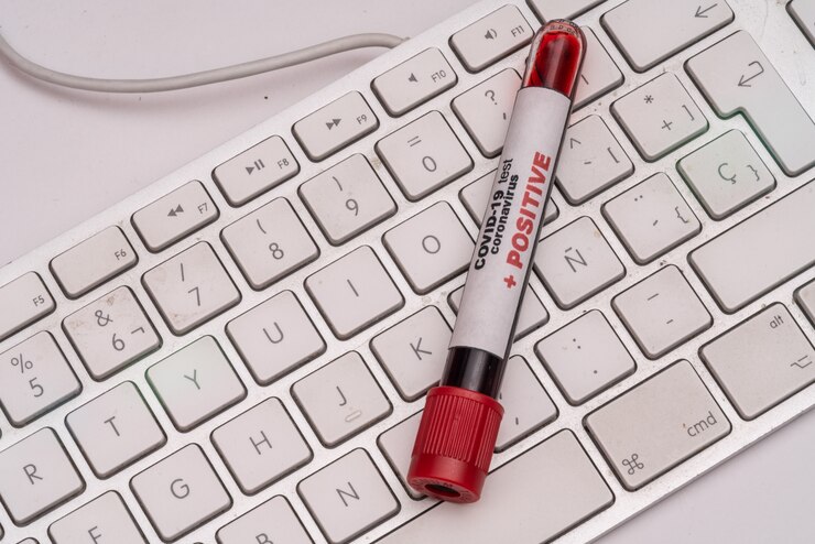 Foto covid 19 coronavirus, muestra de sangre infectada en el tubo de muestra, en el teclado de la computadora, negocio de medicamentos