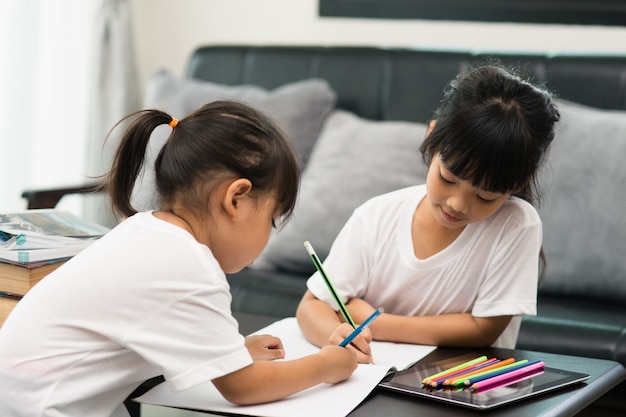 Covid-19 Coronavirus und Lernen von zu Hause, Konzept für Heimschulkinder. Kleine Kinder lernen Online-Lernen von zu Hause aus mit Laptop.