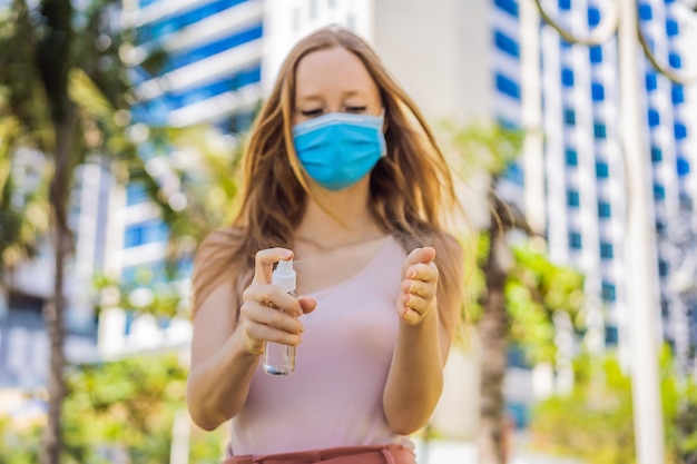 Foto covid-19 pandemia de coronavirus mujer lavando las manos con gel desinfectante de manos contra el nuevo coronavirus 2019ncov o covid-19 en la calle de la ciudad higiene antiséptica y atención médica