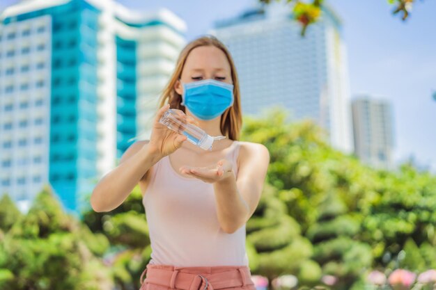 COVID-19 Pandemia de Coronavirus Mujer lavando las manos con gel desinfectante de manos contra el nuevo coronavirus 2019nCoV o COVID-19 en la calle de la ciudad Higiene antiséptica y atención médica