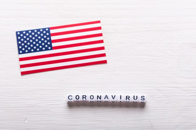 Covid-19, Pandemie- und Viruskonzept - Coronavirus mit amerikanischer USA-Flagge auf weißem Hintergrund.