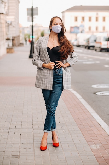 Covid-19 und Luftverschmutzung pm2.5 Konzept. Pandemie, Porträt einer jungen Frau mit Schutzmaske auf der Straße. Konzept Gesundheit und Sicherheit.