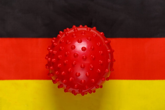 Covid-19-Virusstammmodell auf dem Hintergrund der deutschen Flagge