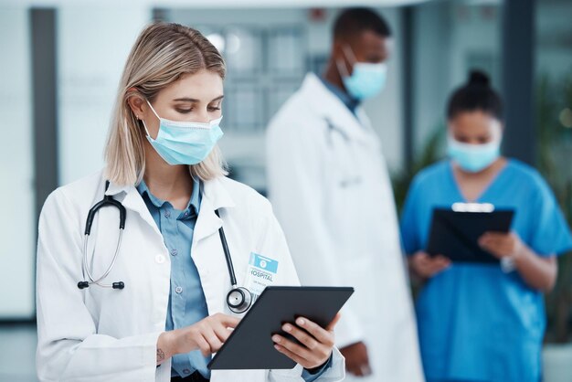 Foto covid mulher médica e tablet para prevenção de resultados e verificação de prontuários de pacientes online telessaúde feminina e equipe com máscaras para cuidados de saúde e tratamento de doenças pergaminho para cura e pesquisa