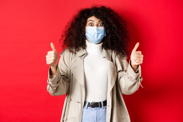 Covid pandemia y concepto de cuarentena chica emocionada con el pelo rizado con gabardina y médico ...