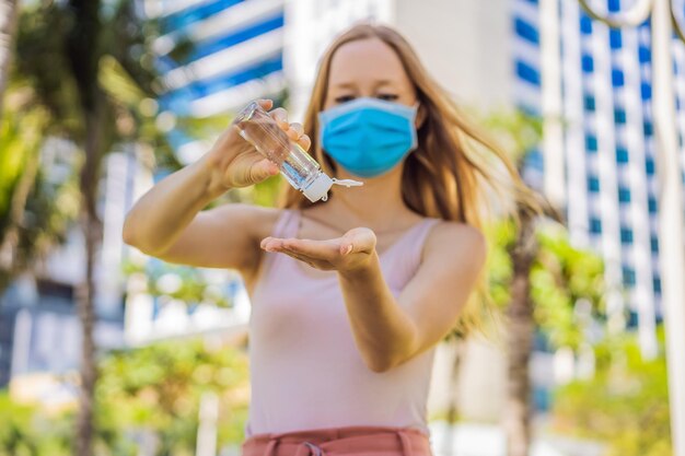 COVID19 Coronavirus pandémico Manos de mujer usando gel desinfectante para manos contra el nuevo coronavirus 2019nCoV o COVID 19 en la calle de la ciudad Higiene antiséptica y atención médica